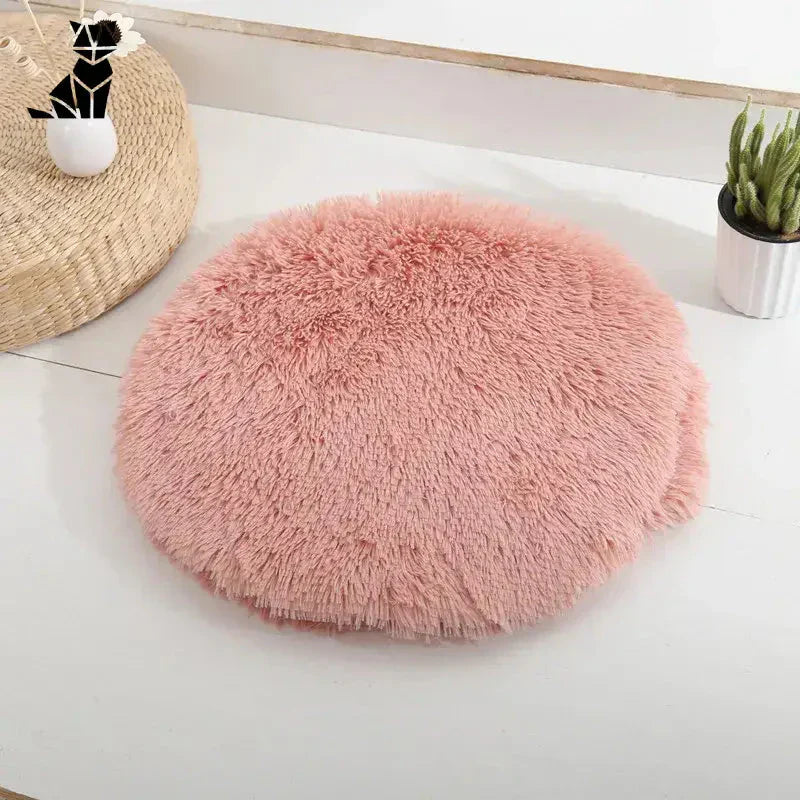 Lit rond rose pour petits chats et chiens sur table blanche